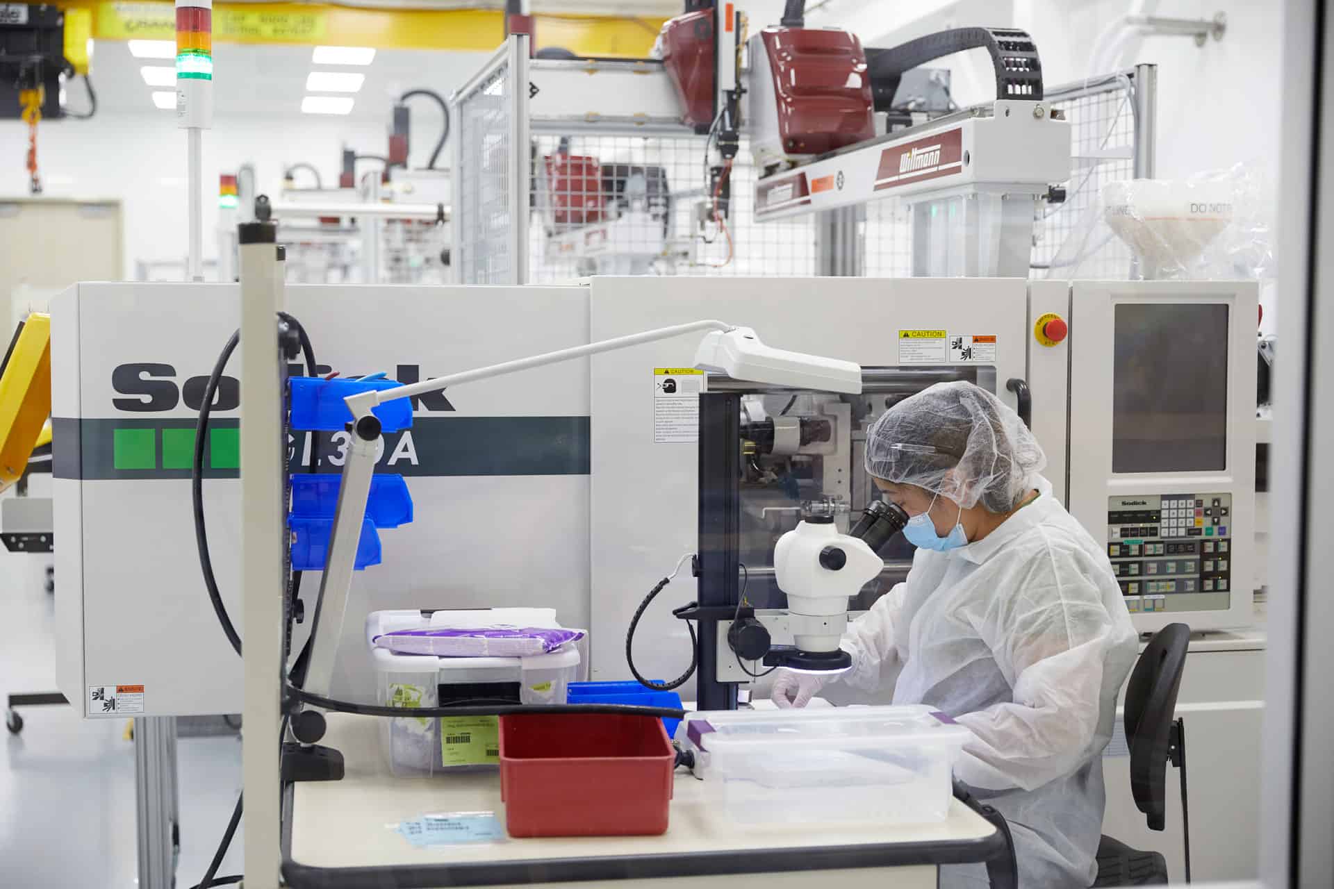 Injection-Molding---possible-main-image---3 Person looking into a microscope.