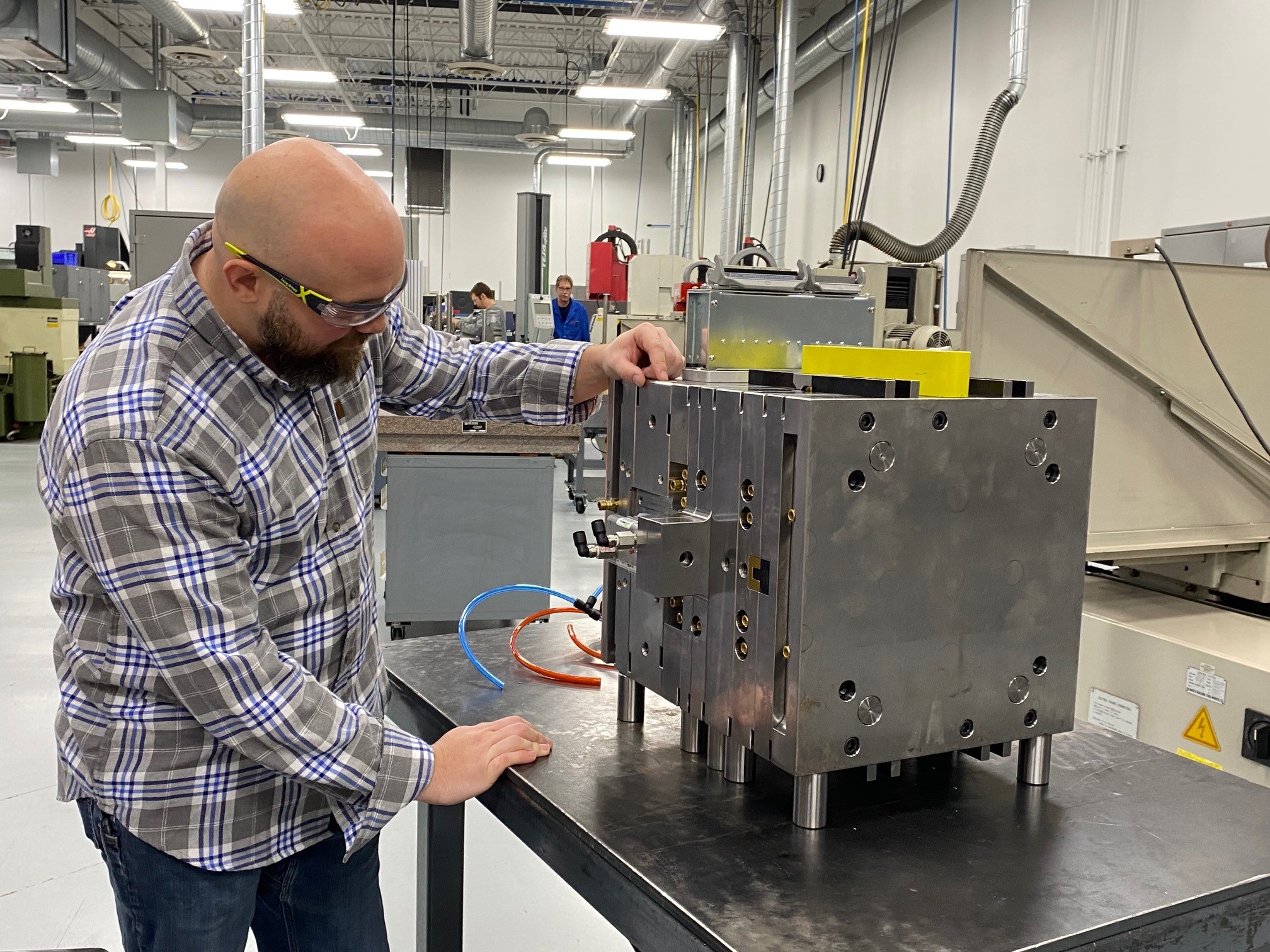 A man in a factory wearing safety glasses.