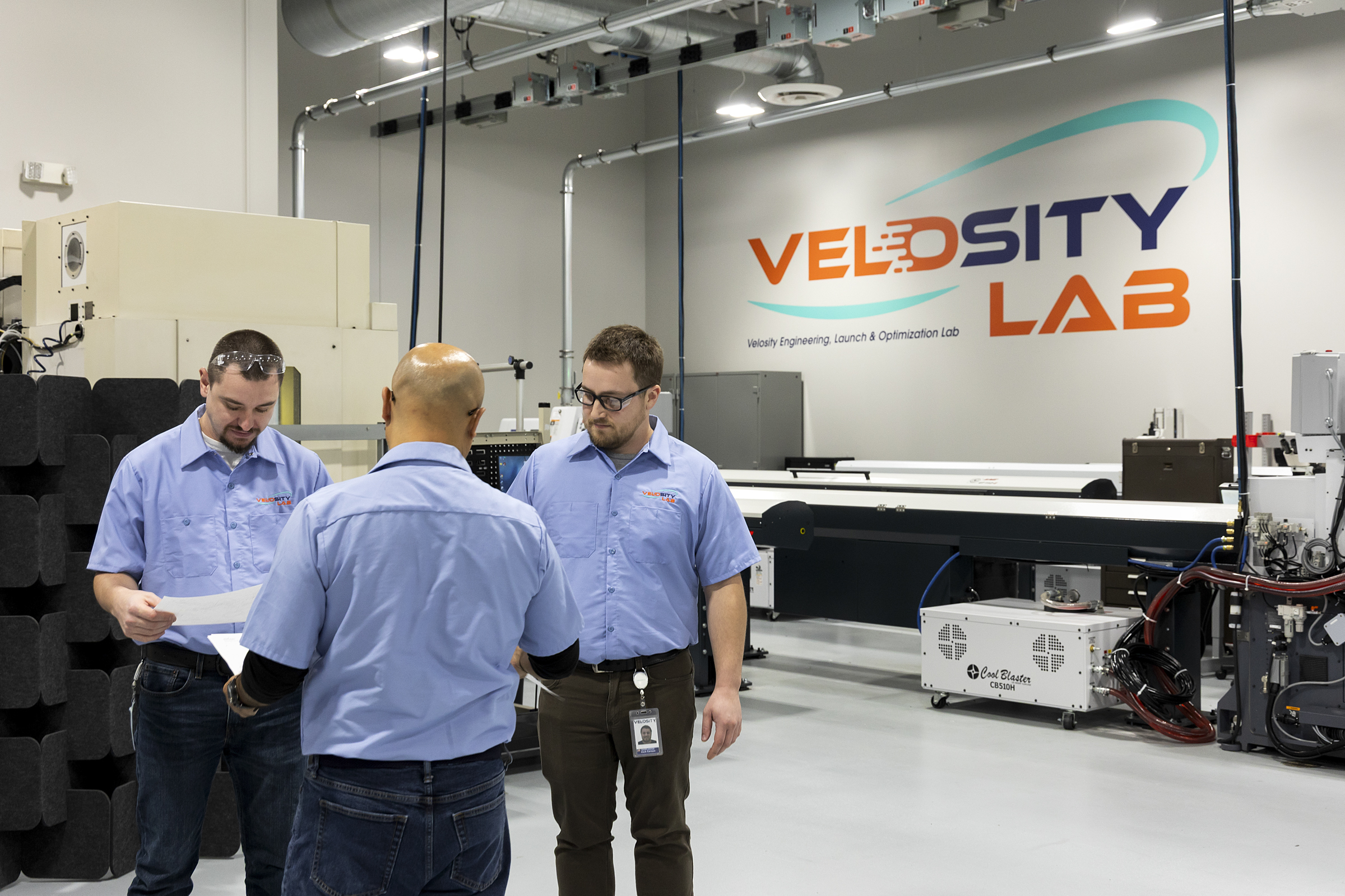 A group of Velosity employees stands in the Velosity Lab