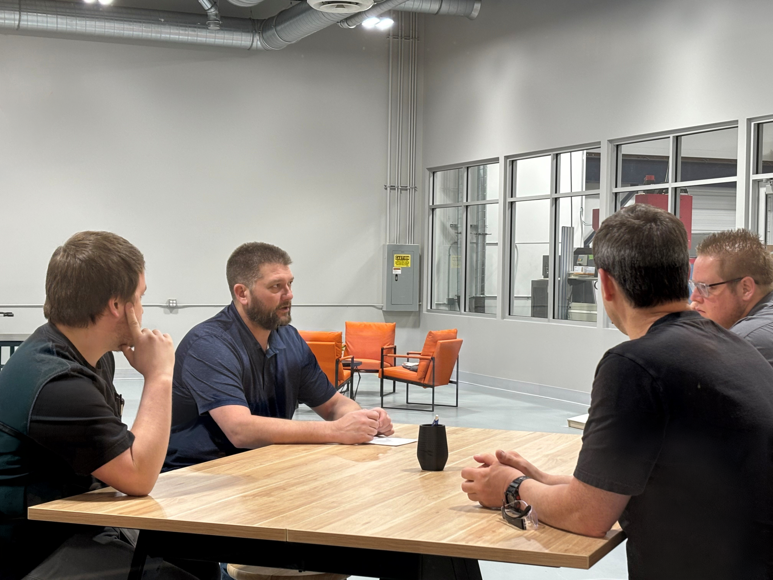 A group of Velosity employees in a meeting in a conference room.