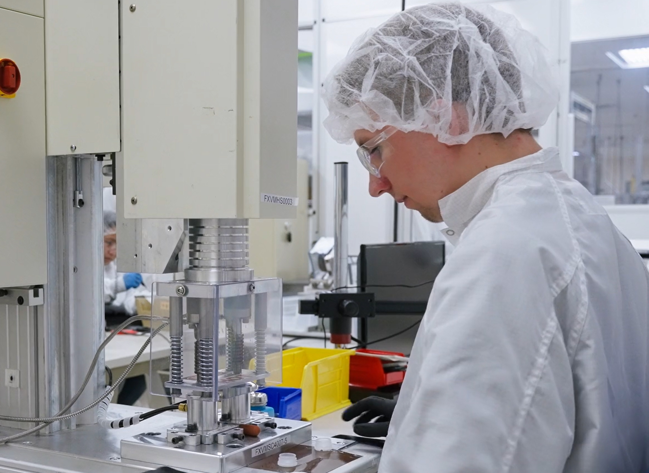 A Velosity employee stands in front of machinery.