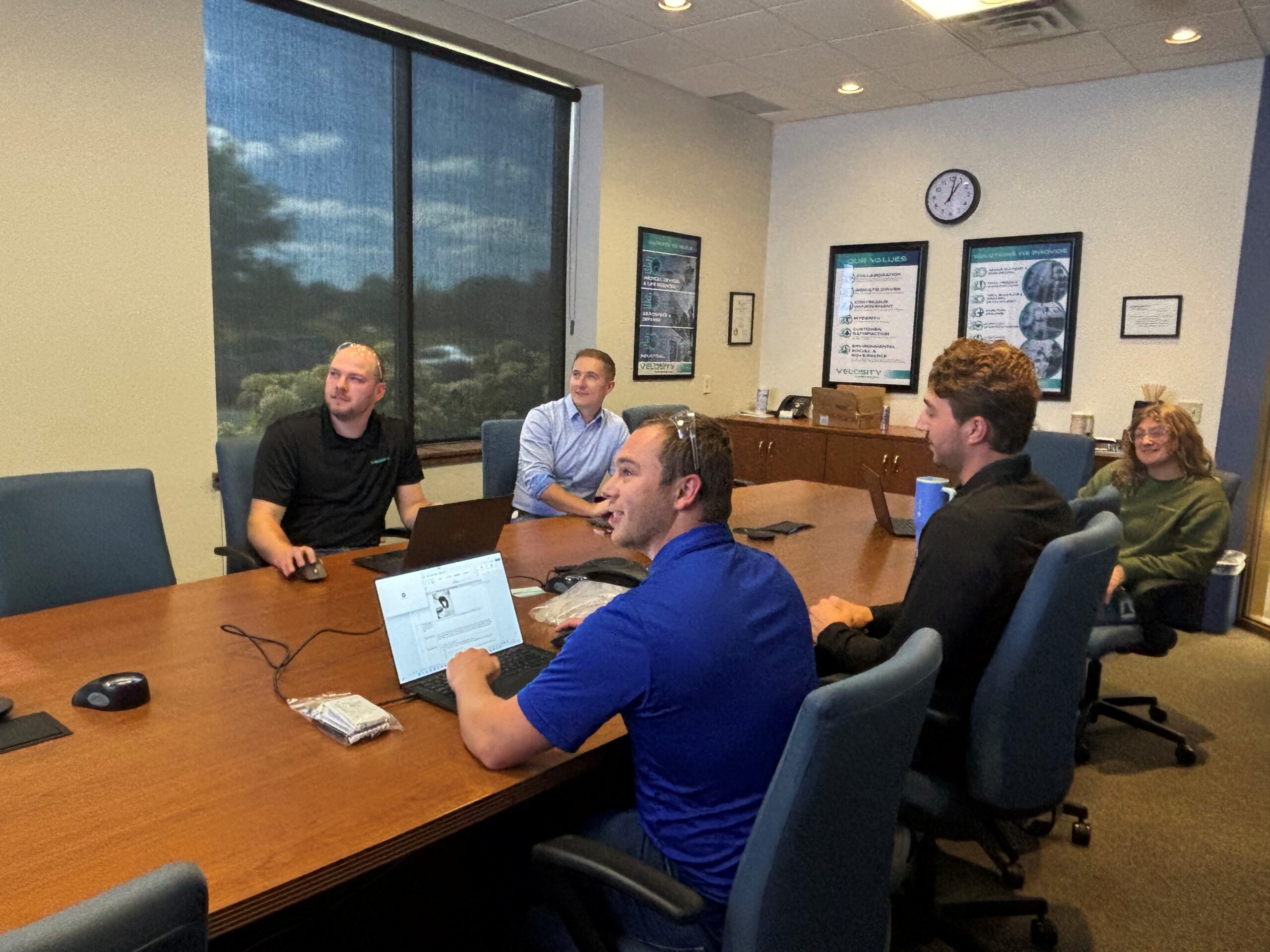 Velosity_Embedded Engineering_DFM Velosity employees gather to look at plans